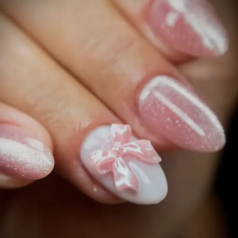 Unhas cor-de-rosa com laço em relevo